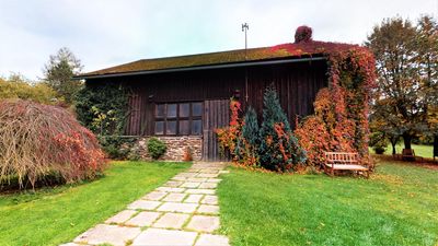 Wooden barn with autumn creeper and the path up to the house