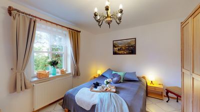 A bedroom with a double bed and a chandelier