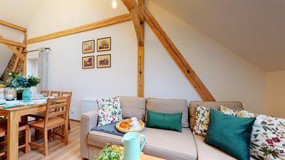 A sofa and dining table under the beams