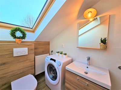 The bathroom with a basin, washing machine and WC