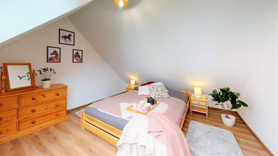 A bedroom with a chest of drawers and a double bed