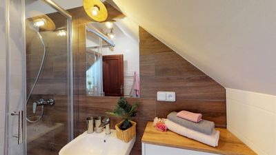 The bathroom with a shower and a basin