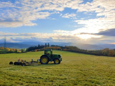 Traktor na louce nad domem