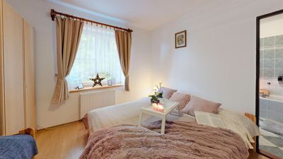 A bedroom with a double bed by the window