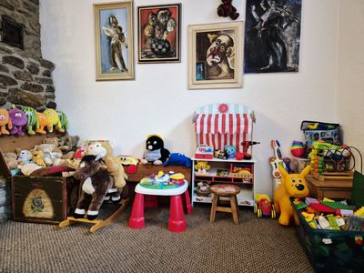 Dětský koutek s truhlou plnou plyšáků, houpacím koněm a dřevěným obchůdkem